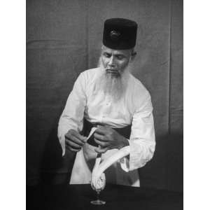 Waiter Mohammed Afiruddin of the Strand Hotel Scupting a Bird Out of a 