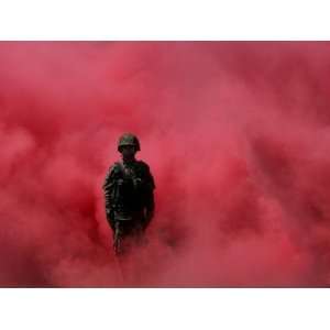 Amidst Smoke from a Flare, a Soldier Attends a Military Ceremony in 
